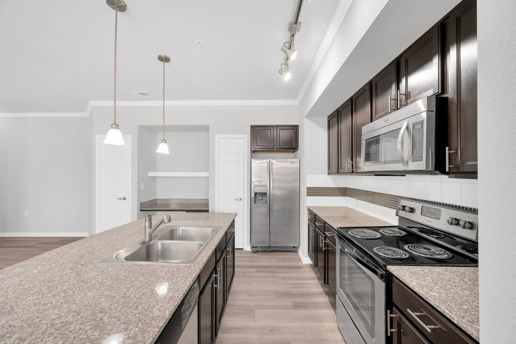 Luxury apartment kitchen with stainless steel appliances, granite countertops, and lots of storage space
